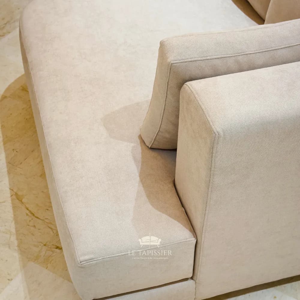 Détail couture accoudoir canapé tissu beige haute finition Détail couture accoudoir canapé tissu beige haute finition